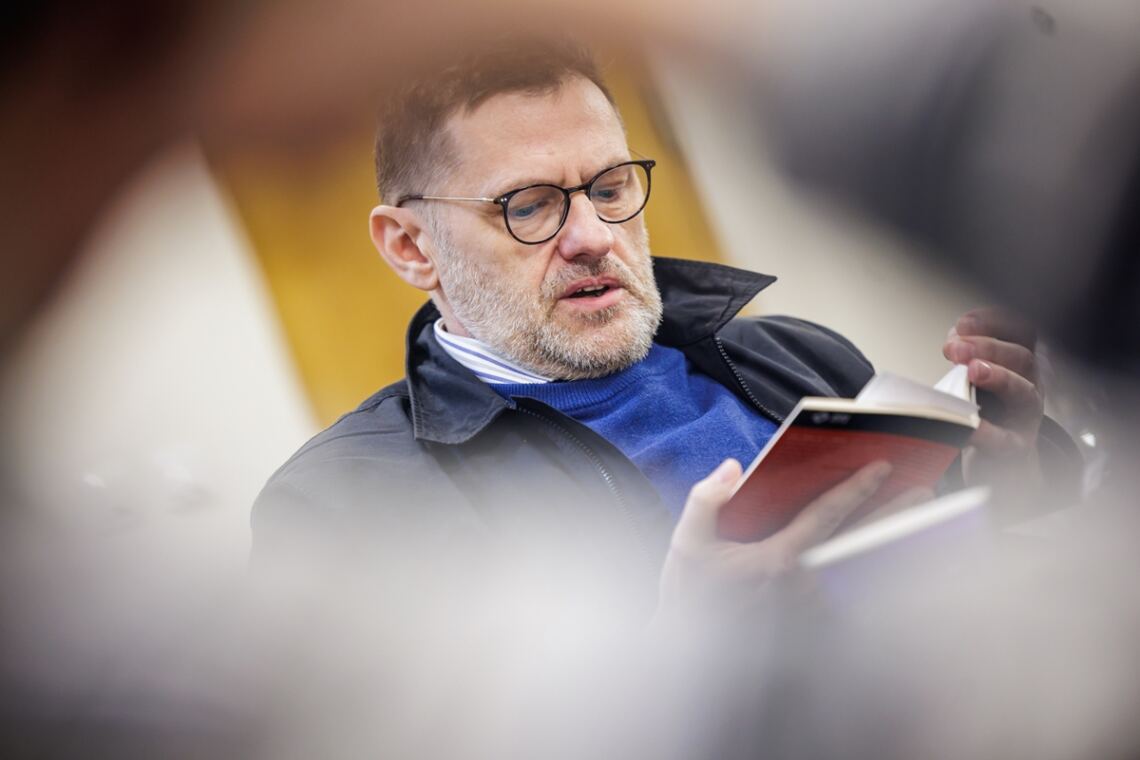 Profesor Zbigniew Kadłubek trzymający w dłoniach otwartą książkę
