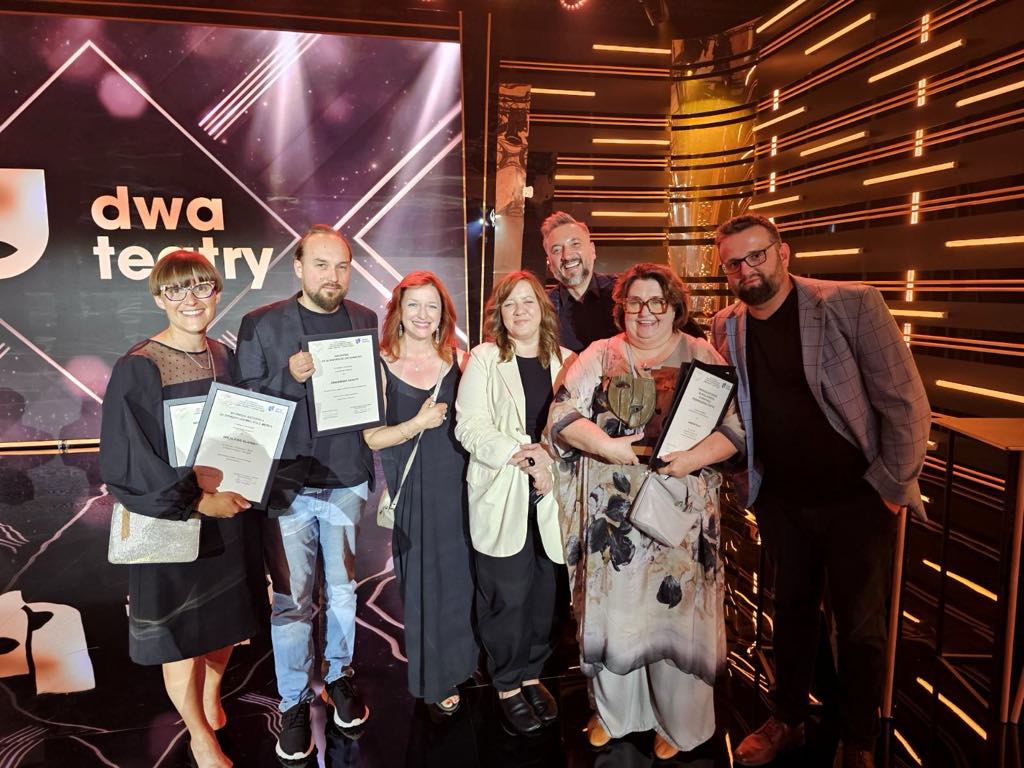 Grupowe zdjęcie aktorów, część z nich trzyma w dłoniach dyplomy