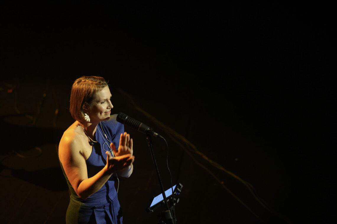 Piosenkarka stojąc przed mikrofonem klaszcze, ujęcie z góry