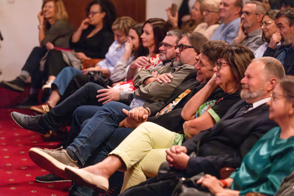 Osoby siedzące w pierwszym rzędzie na widowni