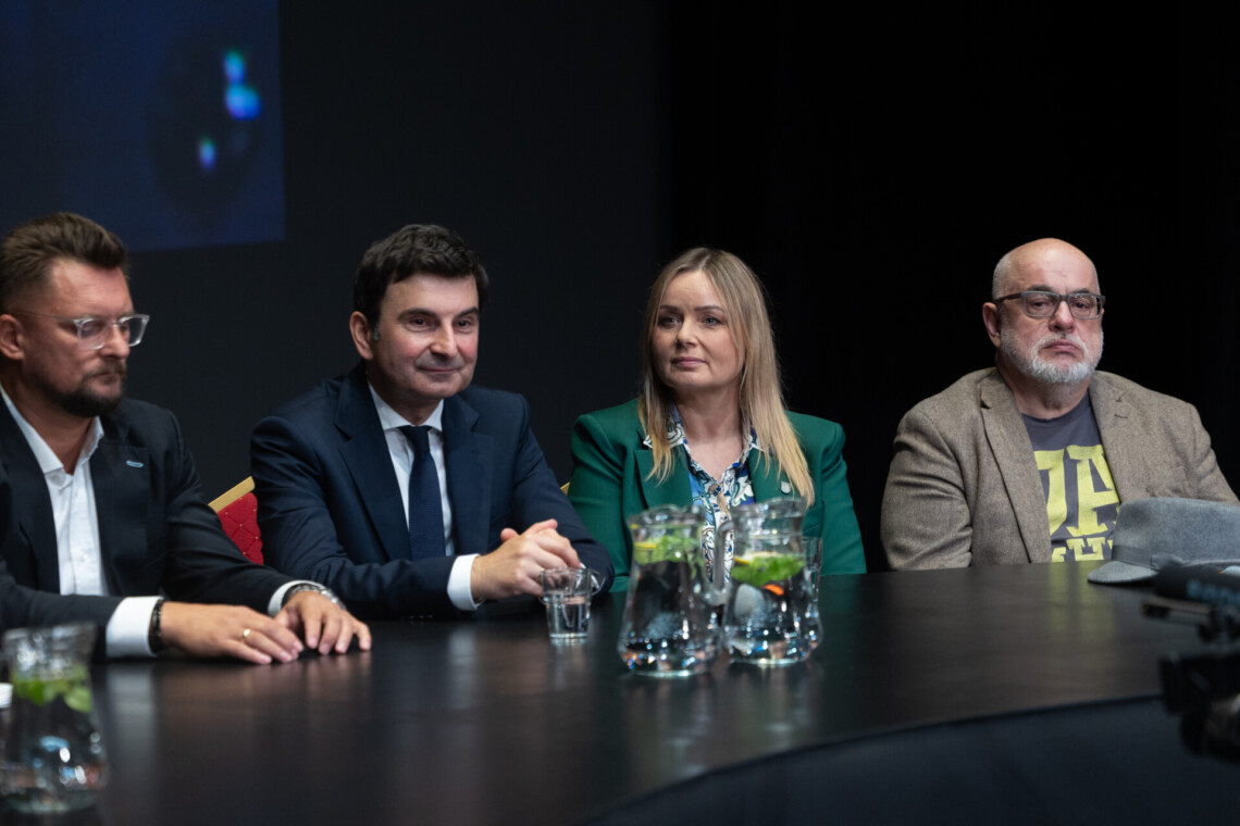 Cztery osoby siedzące za stołem