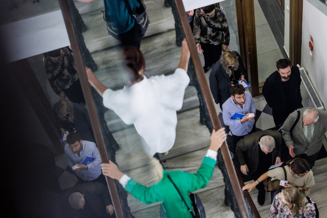 Publiczność wchodząca po schodach prowadzących na scenę w Malarni. Widok z góry. Po lewej stronie lustrzane odbicie wchodzących widzów.