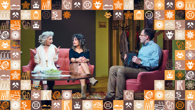 Osoby siedzące w mieszkaniu, z lewej strony na sofie dwie kobiety, z prawej stronie w fotelu mężczyzna, przed nimi okrągły stolik; wokół zdjęcia ramka z małych kwadracików w różnych kolorach (odcienie pomarańczowego i brązowego) przedstawiające obrazki związane ze Śląskiem, np. szyb górniczy, wagon z węglem, kluski śląskie