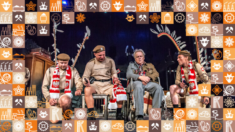 Cztery osoby w rzędzie, mężczyźni po bokach z skrzydłami husarii i szalikami kibicowskimi, mężczyzna z lewej siedzi na taborecie i trzyma w dłoni pistolet, wszyscy trzej są ubrani tak samo, na wzór mundurów z czapkami, dalej na wózku inwalidzkim siedzi starszy mężczyzna z przypiętymi do piersi medalami; wokół zdjęcia ramka z małych kwadracików w różnych kolorach (odcienie pomarańczowego i brązowego) przedstawiające obrazki związane ze Śląskiem, np. szyb górniczy, wagon z węglem, kluski śląskie