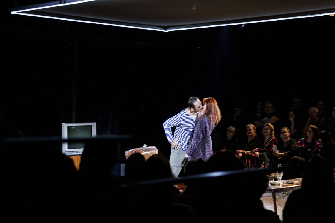 W centrum kobieta i mężczyzna w trakcie pocałunku