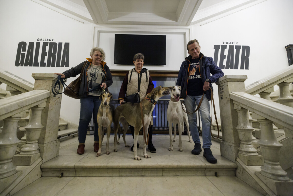 Dwie kobiety i mężczyzna z hartami pozujący do zdjęcia na schodach