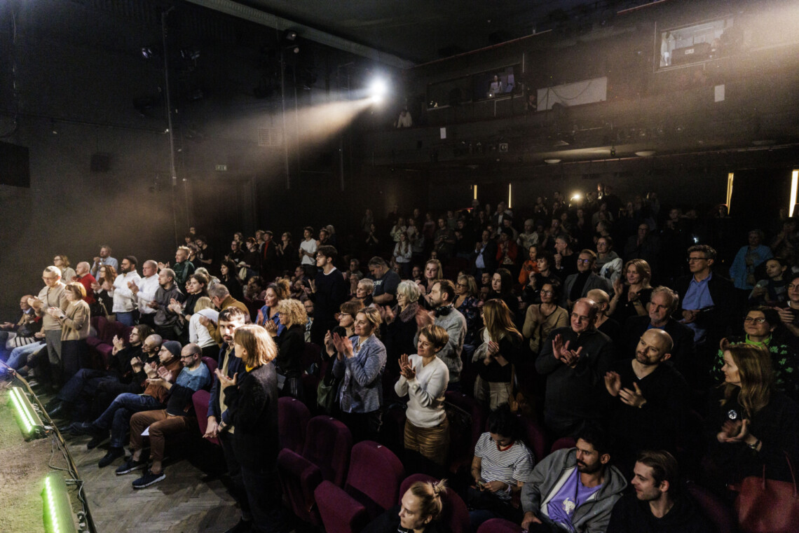 Osoby na widowni, stoją i klaszczą