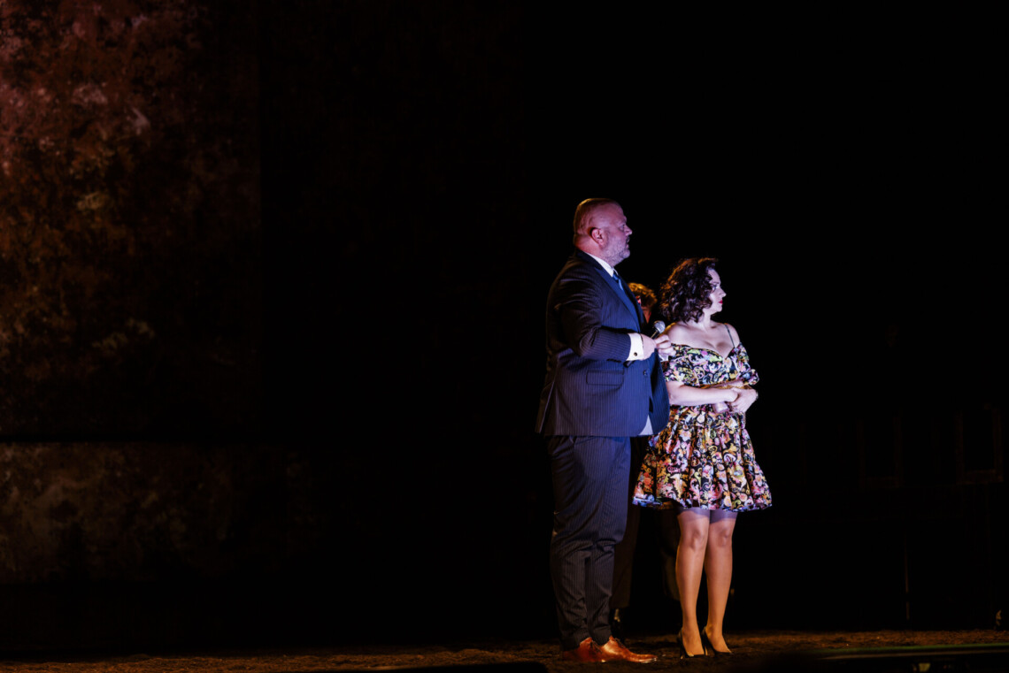 Elegancko ubrani kobieta i mężczyzna stoją na scenie pogrążonej w ciemności