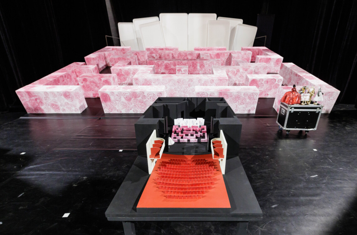 Makiety Dużej Sceny Teatru Śląskiego ze scenografią spektaklu Alicja w Krainie czarów na tle rzeczywistej scenografii do spektaklu