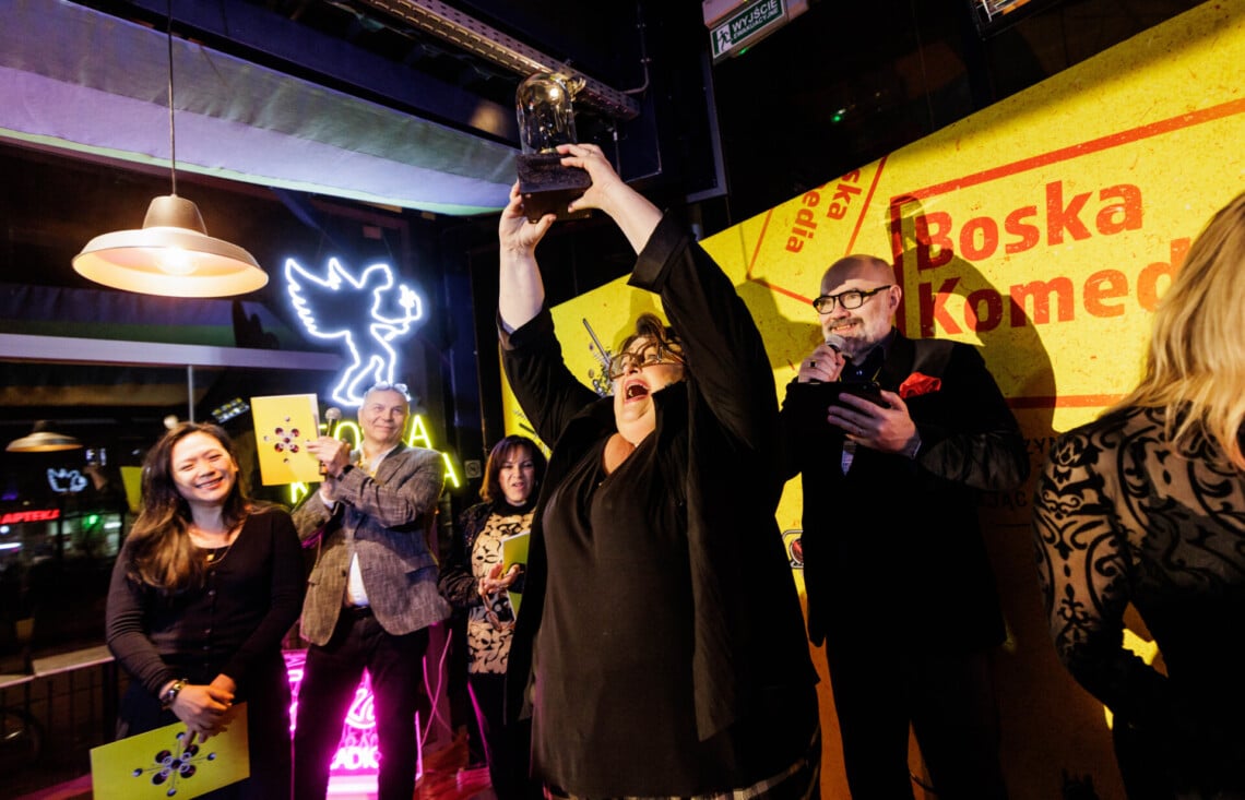 Grażyna Bułka trzyma w dłoniach nagrodę, unosi ją wysoko nad głową